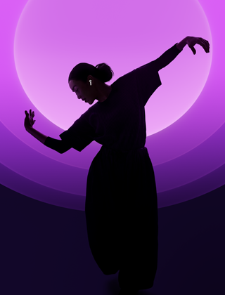 A person dancing while wearing AirPods 5, multi-colour background