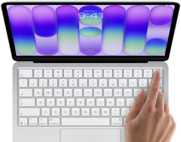 MacBook Neo, silver colour, showing login screen, person’s finger on Touch ID sensor in top-right corner of keyboard
