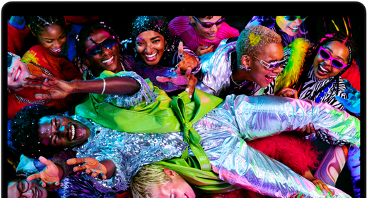 Colourful screen on a MacBook Pro of a person crowd-surfing at a party, showcasing the vibrant Liquid Retina XDR display