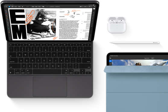 iPad Pro attached to Magic Keyboard, front exterior, space black colour, rounded corners, black display bezel, open, display showing article editing app with text and photograph of a woman playing music, Airpods 4 in open case, blue Smart Folio cover on iPad Pro with Apple Pencil Pro resting atop device, cover slightly open revealing display