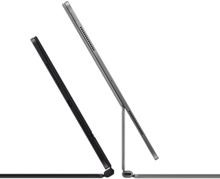 Two iPad Pro devices attached to Magic Keyboard, side exterior, thin profile, space black colour with speakers and USB-C port, tilted half open, silver colour, open, tilted back showing the keyboard’s floating cantilever design, speakers and microphone