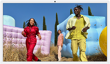 Three people in bright outfits, surrounded by colorful inflatable shapes