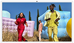 Three people in bright outfits, surrounded by colorful inflatable shapes